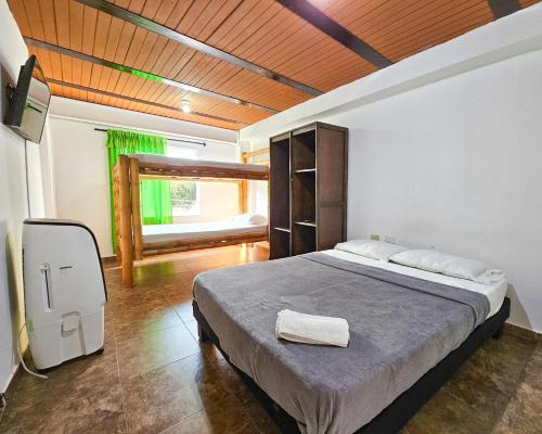 1 dormitorio con 1 cama y TV en La Mercedes Lite Hostal By MH, en Cali