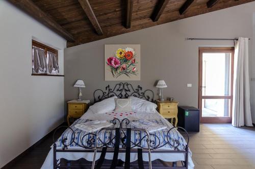 - une chambre dotée d'un lit avec un cadre en fer forgé dans l'établissement Agriturismo Tenuta Belvedere, à Belvedere Ostrense