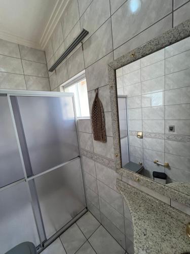 a bathroom with a shower and a mirror at Suíte completa no centro de Sinop in Sinop
