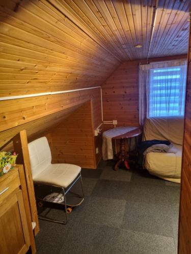 Habitación pequeña con cama y silla. en Dom jednorodzinny., en Tomelilla