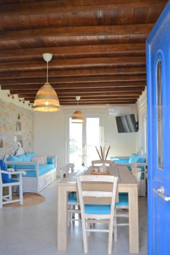 a living room with a table and a blue door at Liogerma Residence in Serifos Chora