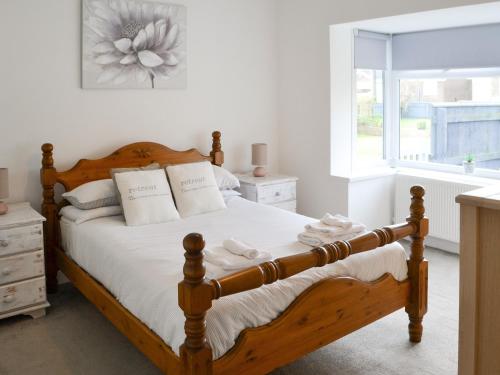 a bedroom with a wooden bed and a window at Carolyn House in Ellington