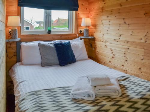 Una cama en una habitación de madera con toallas. en Lancaster - Uk47054 en Holme upon Spalding Moor
