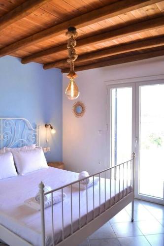 a bedroom with a bed and a window and a ceiling at Liogerma Residence in Serifos Chora