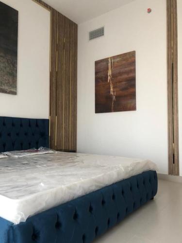 a bed in a room with a blue head board at أجمل مكان in Al Ḩamrīyah