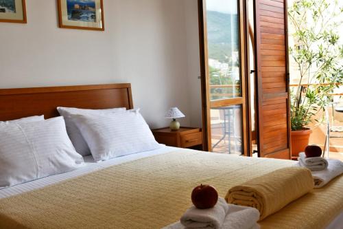 a bedroom with a bed with towels and a balcony at So rooms city centre in Budva