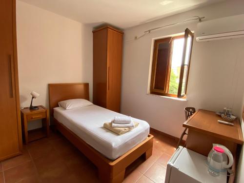 a small bedroom with a bed and a window at So rooms city centre in Budva