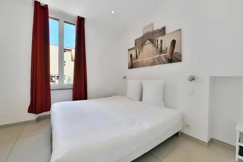 ein weißes Bett in einem Zimmer mit Fenster in der Unterkunft Nice 2 Rooms in the heart of Cannes in Cannes