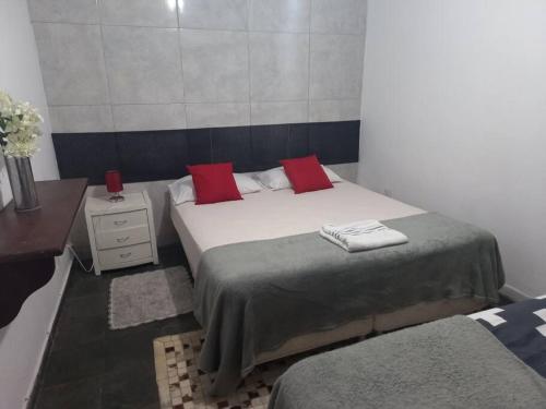 Un dormitorio con una cama con almohadas rojas. en Piscina Casa Floresta/Sta Teresa/Central/Contorno/Serraria Souza Pinto/Area Hospitalar en Belo Horizonte