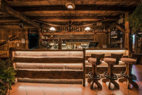 a bar in a restaurant with wooden walls and stools at Oberwirtshof in Rifiano