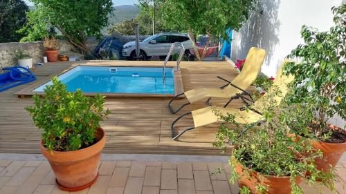 a swimming pool with two chairs and potted plants at "Casa Oliveiras" studio avec terrasse et piscine in Loulé