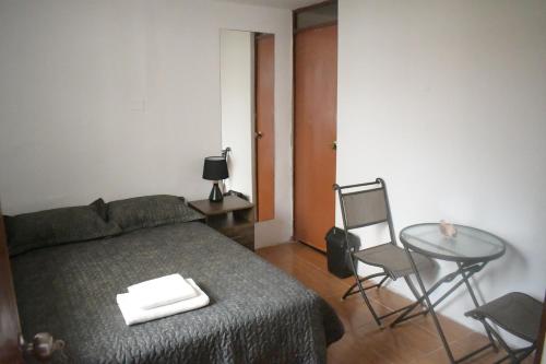 um quarto com uma cama, uma mesa e uma cadeira em Chakana House - Hostel Huanchaco em Huanchaco