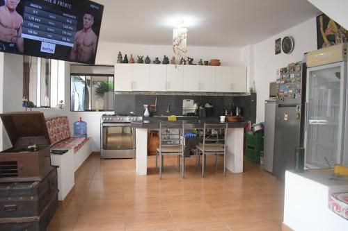 uma cozinha com armários brancos e electrodomésticos de aço inoxidável em Chakana House - Hostel Huanchaco em Huanchaco