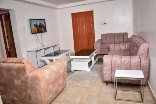 uma sala de estar com dois sofás e uma mesa em Mella homes limuru em Kiambu