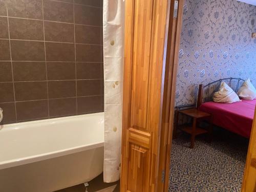 a bathroom with a tub and a bedroom with a bed at Park Hotel Kekava in Ķekava