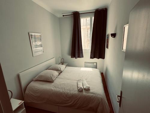 una camera da letto con un letto e un paio di pantofole sopra di Appartement au coeur du Vieux-Port a Marsiglia