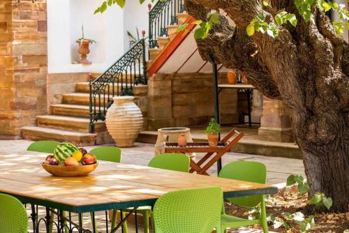 una mesa y sillas con un bol de fruta. en Calvocoressi Estate, en Chios