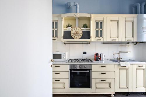 a kitchen with white cabinets and a stove top oven at (5 bedrooms) 3 Seasons Villa on Como Lake in Como