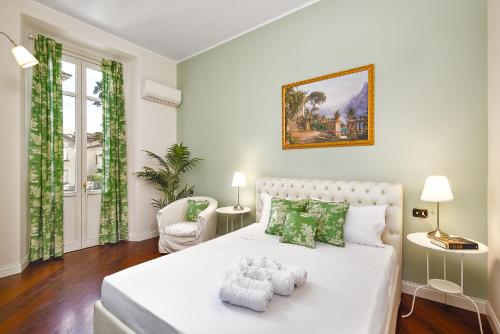 een slaapkamer met een groot wit bed met groene kussens bij (5 bedrooms) 3 Seasons Villa on Como Lake in Como