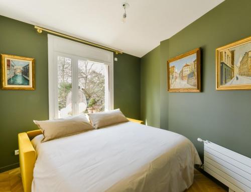 - une chambre avec des murs verts et un lit avec une fenêtre dans l'établissement EXIGEHOME-Comme une maison avec jardin et parking privé, à Versailles