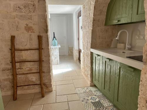 kuchnia z zielonymi szafkami i podłogą wyłożoną kafelkami w obiekcie Trullo Perla Greta - Luxury Country Villa & private heated pool w Alberobello
