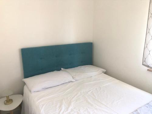 a bed with a blue headboard in a room at Planeta Scalea in Scalea