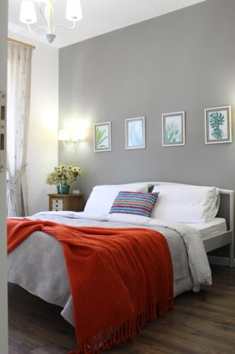 a bedroom with a bed with an orange blanket on it at Vala Mar Apartament in Draç