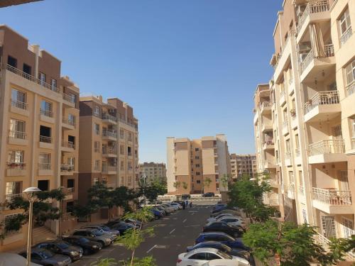 ein Parkplatz mit zwischen Gebäuden geparkt in der Unterkunft مدينتي - القاهرة in Madinaty