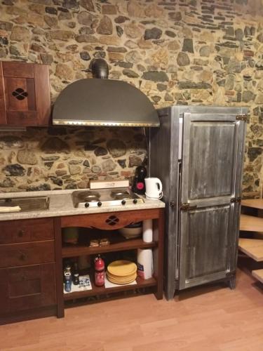 eine Küche mit einem Herd und einer Steinmauer in der Unterkunft La Mimosa di Bellano in Bellano