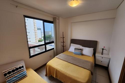 een kleine slaapkamer met een bed en een raam bij Melhor Vista de Salvador in Salvador