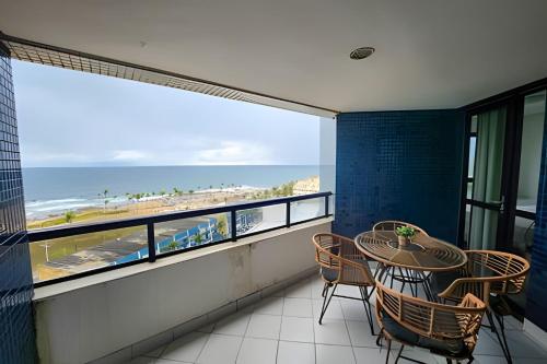 Melhor Vista de Salvador في سلفادور: شرفة مع طاولة وكراسي وإطلالة على الشاطئ