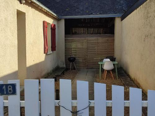 einen weißen Zaun vor einem Haus mit einem Tisch in der Unterkunft Broc in Broc
