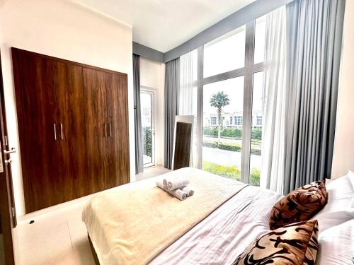 a bedroom with a large bed and a large window at Amazing 1Bedroom Plus Maid in Avencia at Damac Hills 2 in Dubai