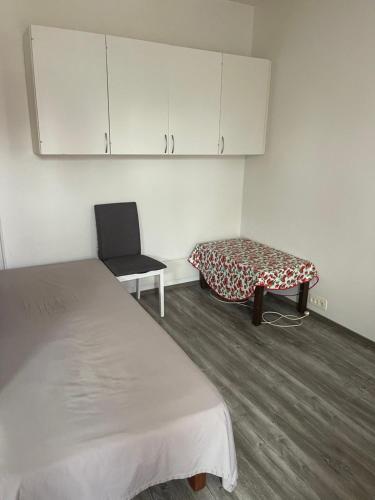 a small room with two beds and a chair at Студия in Kouvola