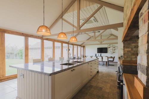 a kitchen with a large island in a room with windows at Newmarket Gem 5-Bedroom Home with Game Room and Cozy Spaces in Brinkley