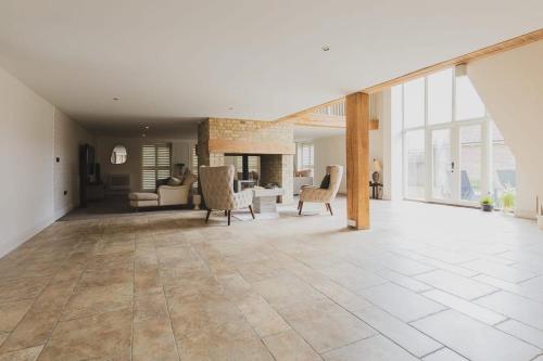 a large living room with white walls and large windows at Newmarket Gem 5-Bedroom Home with Game Room and Cozy Spaces in Brinkley