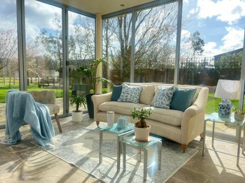 a living room with a couch and a lot of windows at Newmarket Gem 5-Bedroom Home with Game Room and Cozy Spaces in Brinkley
