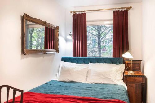 a bedroom with a bed with a mirror and a window at House w/Castle View Garden, Wine, Garage, Netflix in Budapest