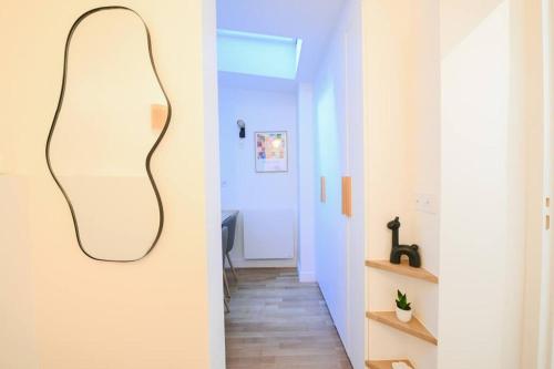 un couloir avec un miroir suspendu au mur dans l'établissement We Parisian The Marais Cozy Home, à Paris