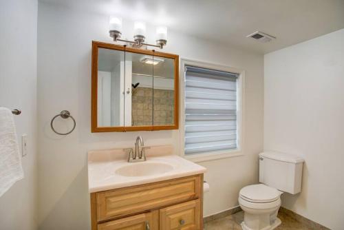 a bathroom with a sink and a toilet and a mirror at Cozy Lux 3bd House Heart of Fishtown Sleeps 8 in Philadelphia