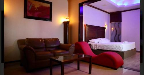 a living room with a couch and a bed at Hotel Dali in Reynosa