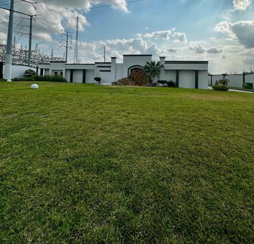 a house with a green lawn in front of it at Hotel Dali in Reynosa