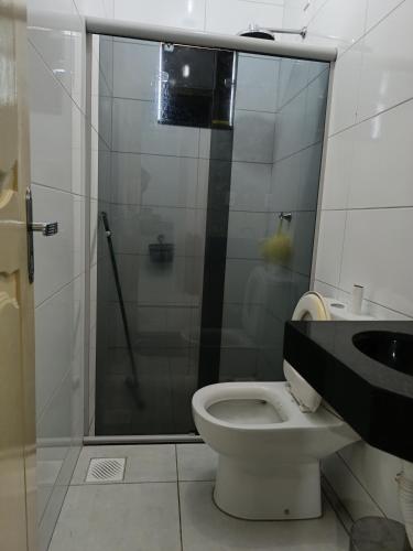 a bathroom with a shower and a toilet and a sink at Home flat in Araguaína