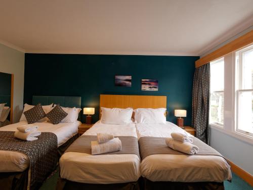 a bedroom with two beds and a green wall at The Ship Inn - Winner Best Hotel Experience 2024 Visit Scotland in Gatehouse of Fleet