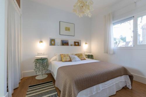 a white bedroom with a bed and a window at CASA LUZ. Casas Los Elementos. in Zahora