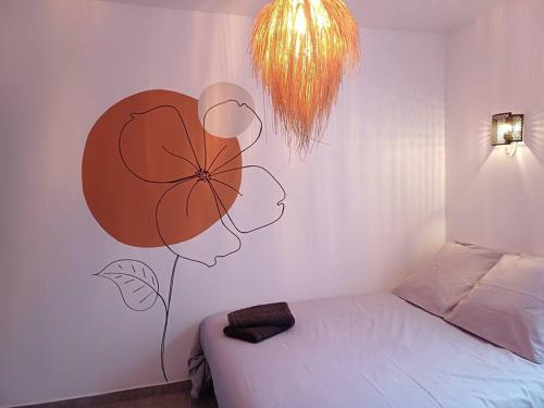ein Schlafzimmer mit einem Bett mit einer Blume an der Wand in der Unterkunft Rêverie des champs - 5 couchages - Proche centre in Amiens