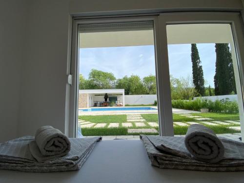 a bedroom with a view of a pool through a window at Vestovis Holiday House in Mostar