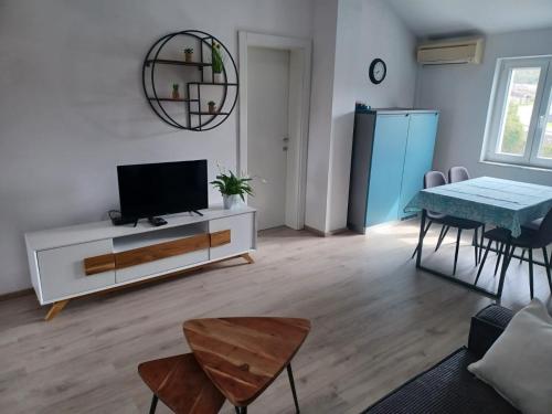 ein Wohnzimmer mit einem TV und einem Tisch in der Unterkunft Apartment Roza in Cres