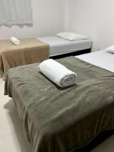 ein Handtuch, das auf zwei Betten in einem Zimmer liegt in der Unterkunft Lindo apartamento de 3 quartos bem amplo próximo a Rua de Lazer Domingos Martins in Domingos Martins