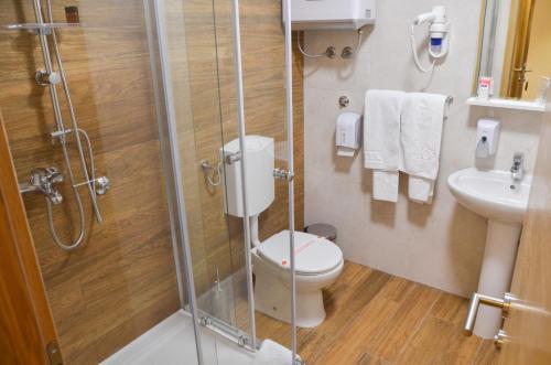 a bathroom with a shower and a toilet and a sink at Hotel JET SET Pale in Pale